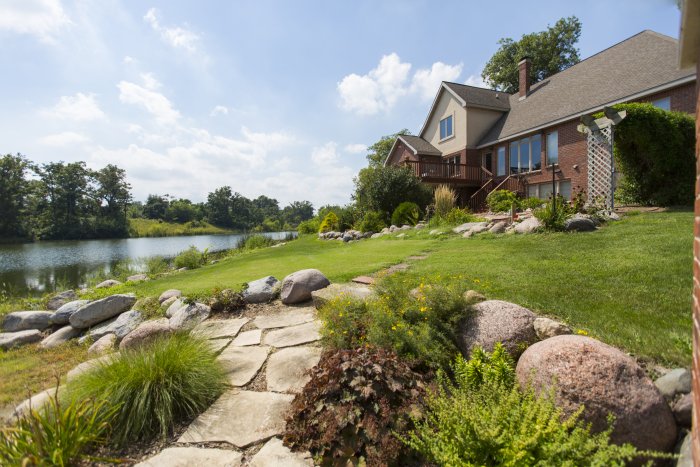 Landscaping with stone paths, near pond in the backyard of a Central Iowa home